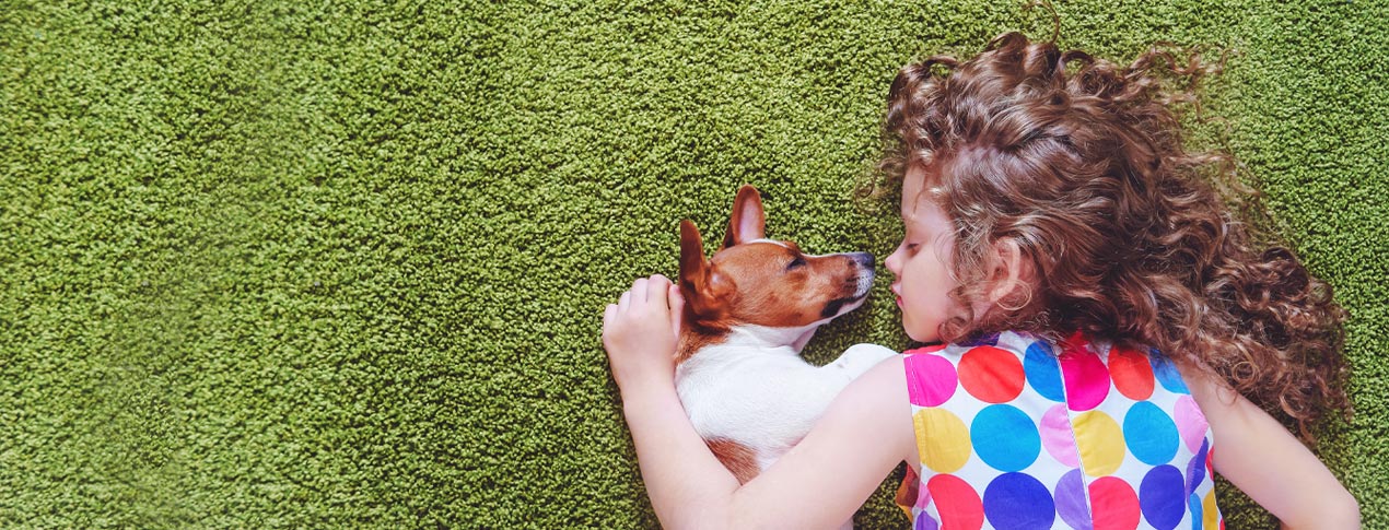 dog and girl laying on top of green carpet cleaned by niagara carpet and cleaning systems environmentally friendly carpet cleaners